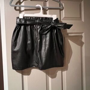 Black faux fur mini skirt. Cute matching bow belt. Size Medium.